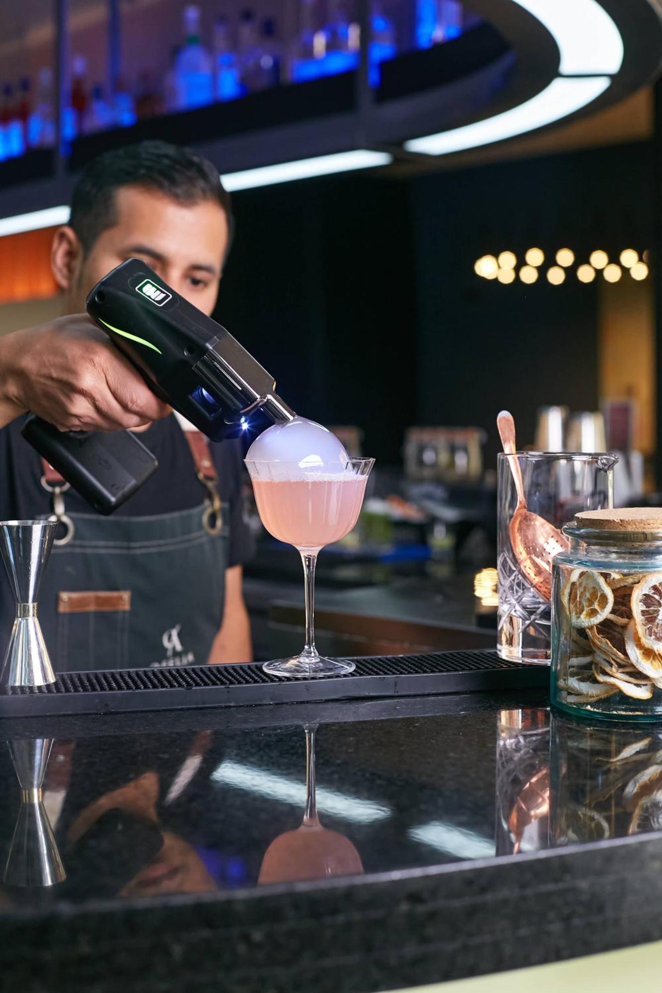 Pullman Santiago Vitacura Exterior photo A bartender using a blowtorch to cook a cocktail